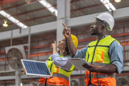 Metal sheet workers at factory plan to install solar panels on roof, promoting renewable energy, reducing costs, registering carbon credits for sustainable and efficient way to combat climate change.