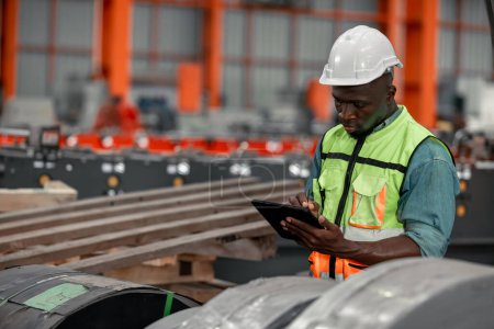 Foto de Los trabajadores de chapa metálica monitorean la calidad con precisión, utilizando tabletas digitales para documentación y certificación, mejorando la garantía ambiental en proyectos de techos industriales e infraestructura. - Imagen libre de derechos