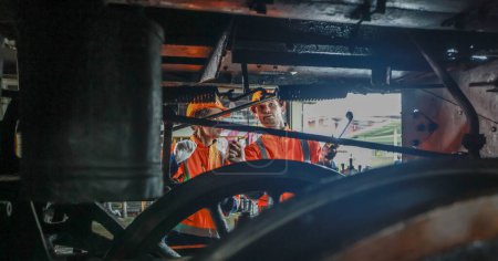 Foto de Los técnicos de ingeniería de locomotoras mantienen el control de emisiones en los ferrocarriles, identificando fugas de petróleo y combustible e inspeccionando, probando y reparando motores defectuosos para una eficiencia óptima. - Imagen libre de derechos