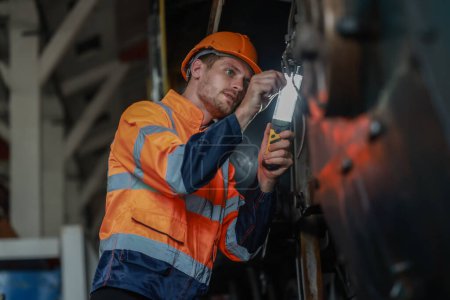 Foto de Los técnicos de ingeniería de locomotoras mantienen el control de emisiones en los ferrocarriles, identificando fugas de petróleo y combustible e inspeccionando, probando y reparando motores defectuosos para una eficiencia óptima. - Imagen libre de derechos