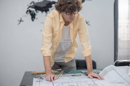 Photo for Multicultural team of architects collaborates on a low-carbon building project, analyzing blueprints, drafting layouts, calculating precise structures and materials for eco-friendly construction. - Royalty Free Image