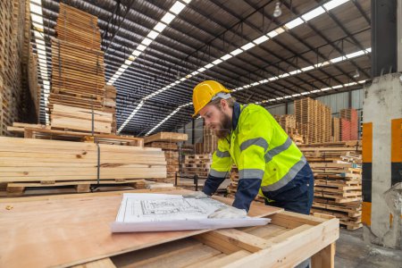 Photo for Woodworkers assess blueprints, select low-carbon materials, follow schemes for eco-friendly production. Quality, environmental responsibility are reflected in precise assembly, meeting high standards - Royalty Free Image