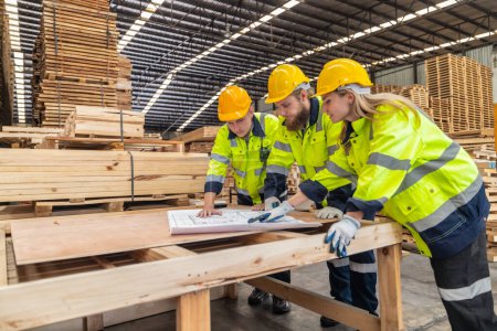Photo for Woodworkers assess blueprints, select low-carbon materials, follow schemes for eco-friendly production. Quality, environmental responsibility are reflected in precise assembly, meeting high standards - Royalty Free Image