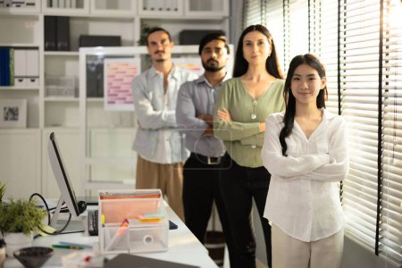 Photo for A portrait of a multicultural startup team standing in line, showcasing confidence and unity in their contemporary office space, emphasizing collaboration and diversity. - Royalty Free Image