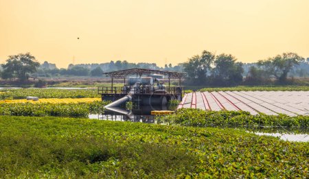 Foto de Una máquina de sistema de gestión del agua trabaja junto con una granja solar flotante de última generación, mostrando la mezcla armoniosa de tecnología de energía renovable con el medio ambiente natural. - Imagen libre de derechos