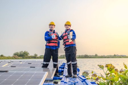 Photo for Two technicians stand poised and attentive amidst a vast array of solar panels on a floating solar farm, as the evening light fades in the background. - Royalty Free Image