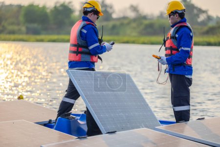 Photo for Floating solar farming technicians inspect electrical systems to ensure proper wiring, polarity, grounding, and termination reliability.  Ensuring compliance with safety regulations and procedures. - Royalty Free Image