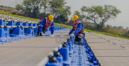 Photo for Two solar farming engineers are intently studying a set of blueprints while conducting a precision standard inspection among rows of photovoltaic panels. - Royalty Free Image