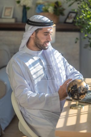 Foto de Sheikh, CEO en vestido árabe, supervisando negocios, reuniones a distancia, y la comunicación a través de videollamadas con el equipo con un gesto de sonrisa. Supervisar las operaciones como líder, mostrando responsabilidades. - Imagen libre de derechos