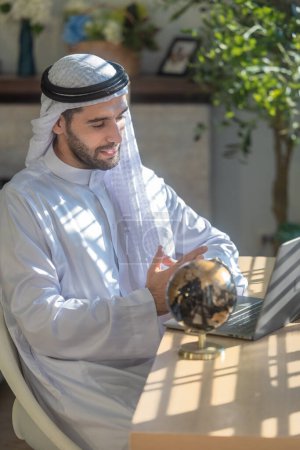 Sheikh, CEO in arb dress, überwacht Geschäfte, ferne Meetings und kommuniziert per Videotelefon mit dem Team mit einer Geste des Lächelns. Als Führungskraft Operationen überwachen, Verantwortlichkeiten aufzeigen.