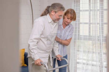 Photo for An elderly couple uses walking aids while assisting each other in an indoor setting, highlighting their mutual care. - Royalty Free Image