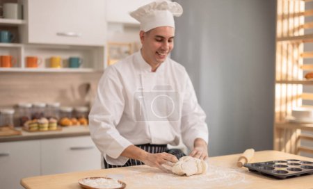 Téléchargez les photos : Chef cuisinier professionnel pétrissant intensément sur une surface de farine aux premières étapes de la fabrication du pain dans une cuisine commerciale. Mettre en valeur les compétences, la technique, la précision, la passion et l'art pour la nourriture. - en image libre de droit