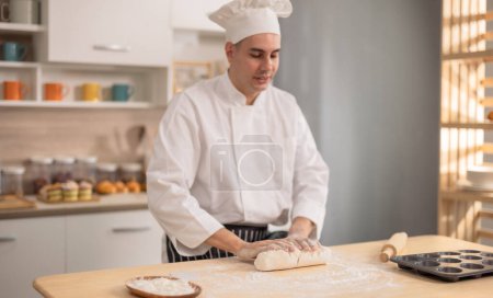 Photo for Professional master chef intently kneading on a flour surface at initial stages of bread making in a commercial kitchen. Showcasing skills, technique, precision, passion and artistry for food. - Royalty Free Image