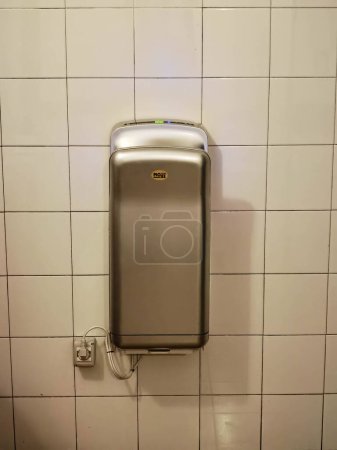 Photo for Electric hand dryer for bathroom, in a public toilet for paper saving - Royalty Free Image
