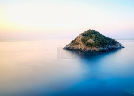 Photo for The island of bergeggi in the middle of the silk effect sea on a quiet summer morning in western liguriain 2021 - Royalty Free Image