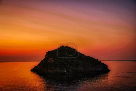 Téléchargez les photos : L'île de bergeggi lors d'un coucher de soleil aux couleurs vives d'une belle soirée d'été en 2022 - en image libre de droit