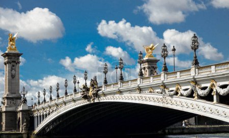 Téléchargez les photos : Le pont Alexandre III est un pont de Paris sur la Seine qui relie le Grand Palais et le Petit Palais au Htel des Invalides.L'imposante construction, destinée à célébrer l'alliance franco-russe signée par le tsar Alexandre III - en image libre de droit