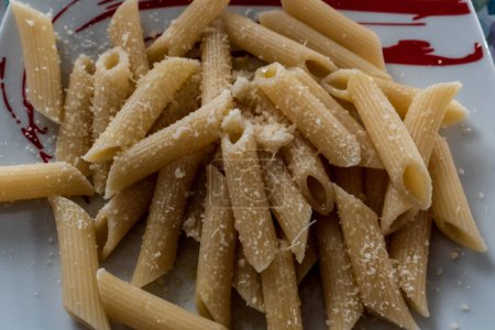 plate of penne in white with cheese. Pasta in bianco is a quick, tasty recipe. An absolutely simple recipe, it is particularly loved after days of excessive eating