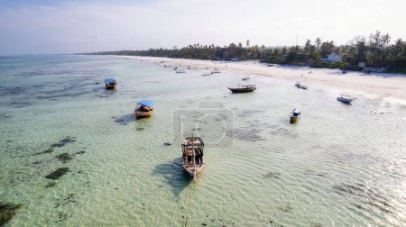 Foto de Zanzíbar parece el paraíso en este tiro con drones, con una hermosa playa y barcos de madera dejados atrás en la marea baja. - Imagen libre de derechos