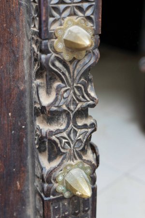 Foto de Echa un vistazo más de cerca a las obras maestras de madera de las puertas de Stone Town en Zanzíbar. Estas puertas son un verdadero reflejo de la rica cultura e historia de la ciudad, con intrincadas tallas y diseños que muestran el pasado y el presente de la ciudad. - Imagen libre de derechos