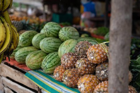 Foto de Colorful fruits on display at a bustling Zanzibar fruit stand are a treat for the senses. From sweet pineapples to fragrant mangos, there's a flavor for everyone. Visit Zanzibar's fruit markets for a taste of local culture. - Imagen libre de derechos
