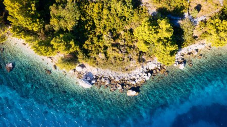 Foto de The stunning beauty of Croatia's rocks and forests is captured in this breathtaking aerial view. Take in the turquoise waters and beach from above, and add this travel image to your collection of unforgettable memories. - Imagen libre de derechos