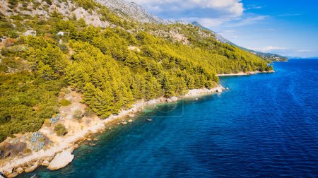 Foto de Asista a la reunión del mar Adriático y a una escarpada ladera rocosa croata, donde los islotes Pakleni y sus cristalinas aguas turquesas se pueden admirar desde lejos.. - Imagen libre de derechos
