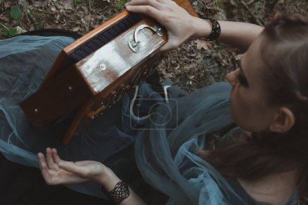 Photo for Female druid puzzling mystery box out scenic photography. Picture of beautiful woman with natural blurred on background. High quality wallpaper. Photo concept for ads, travel blog, magazine, article - Royalty Free Image