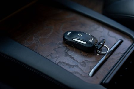 Close up of car key remote control alarm system charm in new electric vehicle interior. Remote control key in the modern electric car. Concept transport travel.