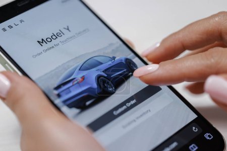 Photo for CALIFORNIA, USA - NOVEMBER 14, 2022: Close up of a smart phone screen browsing the different tesla models on their website for sale. Tesla website, buying a tesla car online. Tesla SUV Model Y - Royalty Free Image