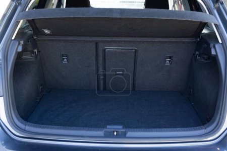 Rückansicht des offenen Kofferraums. Modernes Fließheck-Auto mit offenem, leeren Kofferraum. Der Kofferraum ist für Gepäck geöffnet. Viel Platz für Koffer und Taschen. Bereit für eine Reise