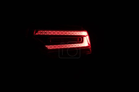 Téléchargez les photos : Détail rapproché sur l'un des feux arrière rouges LED voiture de luxe moderne. Extérieur détail automobile. Feu arrière. Détail sur le feu arrière d'une voiture. Feux arrière de voiture brillant. - en image libre de droit