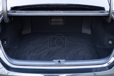 Rear view of the car open trunk. Modern sedan car with open empty trunk. The car boot is open for luggage. A lot of space for coffers and bags. Ready for a trip.