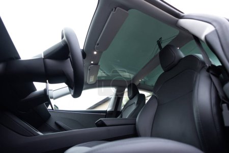 Panoramic glass sun roof in the new electric car. Clean glass and view from inside to the sky. Sunroof hatch with tinted glass. Automotive sunroof. Hatch in car roof.