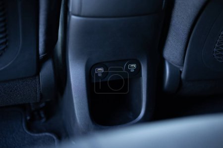 Panel in interior of a new electric car. Two USB ports for the rear seats in a passenger car. Modern electric car usb socket for charging and accessories. Car interior