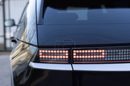 Téléchargez les photos : Détail rapproché sur l'un des feux arrière rouges LED voiture de luxe moderne. Les feux arrière de la voiture brillent. Extérieur détail automobile. Feu arrière. Détail sur le feu arrière d'une voiture. - en image libre de droit