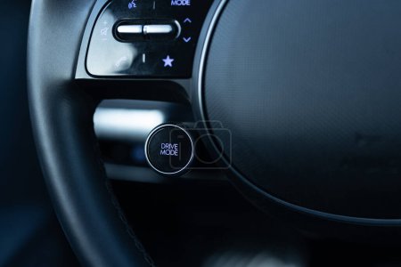 Drive mode button on luxury electric car dashboard. Relaxed and fuel efficient driving mode. Energy-saving button DRIVIE MODE is working while driving, energy-saving driving mode.
