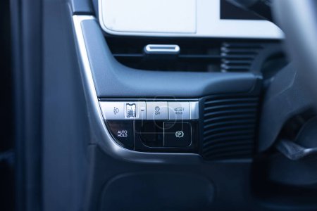 Botón de retención automática en un vehículo moderno. Control electrónico del programa de estabilidad ESP. Detalle interior de un coche eléctrico moderno. Botón ESP. Interruptor de luz. Botón de luz atenuante.