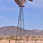 wind Pump in Namibia desert Africa Blue Sky Mountains Wind energy. High quality photo