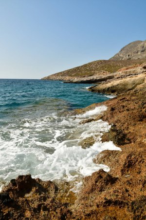 Téléchargez les photos : Des vagues ont frappé des rochers sur le rivage de l'île grecque de Kalymnos été eau du soleil. Illustration 3D de haute qualité - en image libre de droit