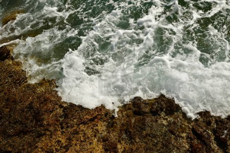 Téléchargez les photos : Des vagues ont frappé des rochers sur le rivage de l'île grecque de Kalymnos été eau du soleil. Illustration 3D de haute qualité - en image libre de droit