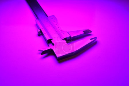 Foto de Calibrador mesure equipo escala engeneering micrómetro precisión luz púrpura. Foto de alta calidad - Imagen libre de derechos