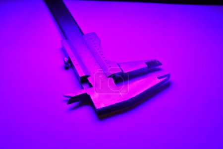Photo for Caliper mesure equipment scale engeneering micrometer precision purple light. High quality photo - Royalty Free Image