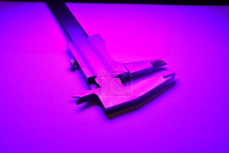 Photo for Caliper mesure equipment scale engeneering micrometer precision purple light. High quality photo - Royalty Free Image