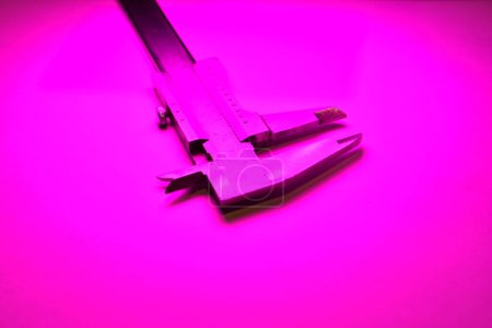 Photo for Caliper mesure equipment scale engeneering micrometer precision pink light. High quality photo - Royalty Free Image