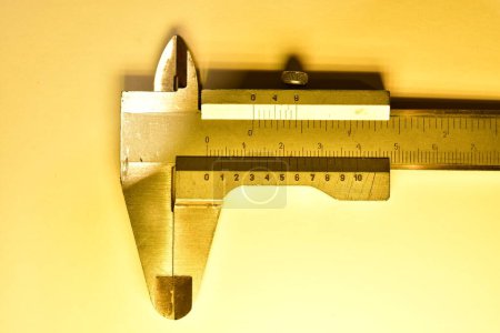 Photo for Caliper mesure equipment scale engeneering micrometer precision yellow light. High quality photo - Royalty Free Image