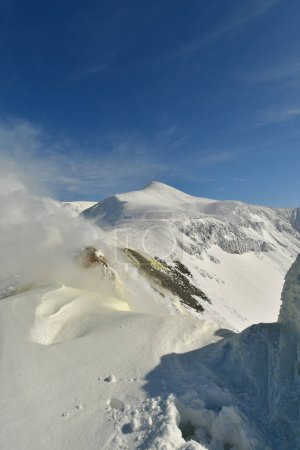 Humo que sube del paisaje invernal nevado Mt. Volcán Tokachi, Hokkaido, Japón. Foto de alta calidad