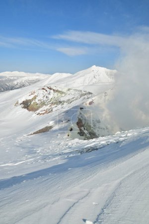 Smoke rising from winter landscape snow-capped Mt. Tokachi volcano, Hokkaido, Japan. High quality photo