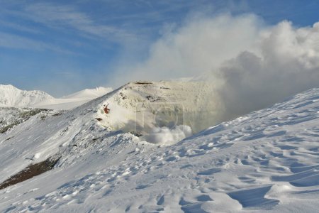 Rauch steigt aus der schneebedeckten Winterlandschaft auf. Vulkan Tokachi, Hokkaido, Japan. Hochwertiges Foto