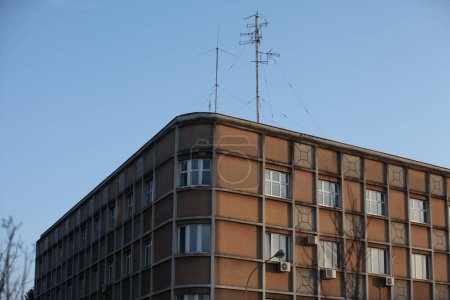 Photo for Corner of an old apartment building, antenna on the roof, blue sky - Royalty Free Image